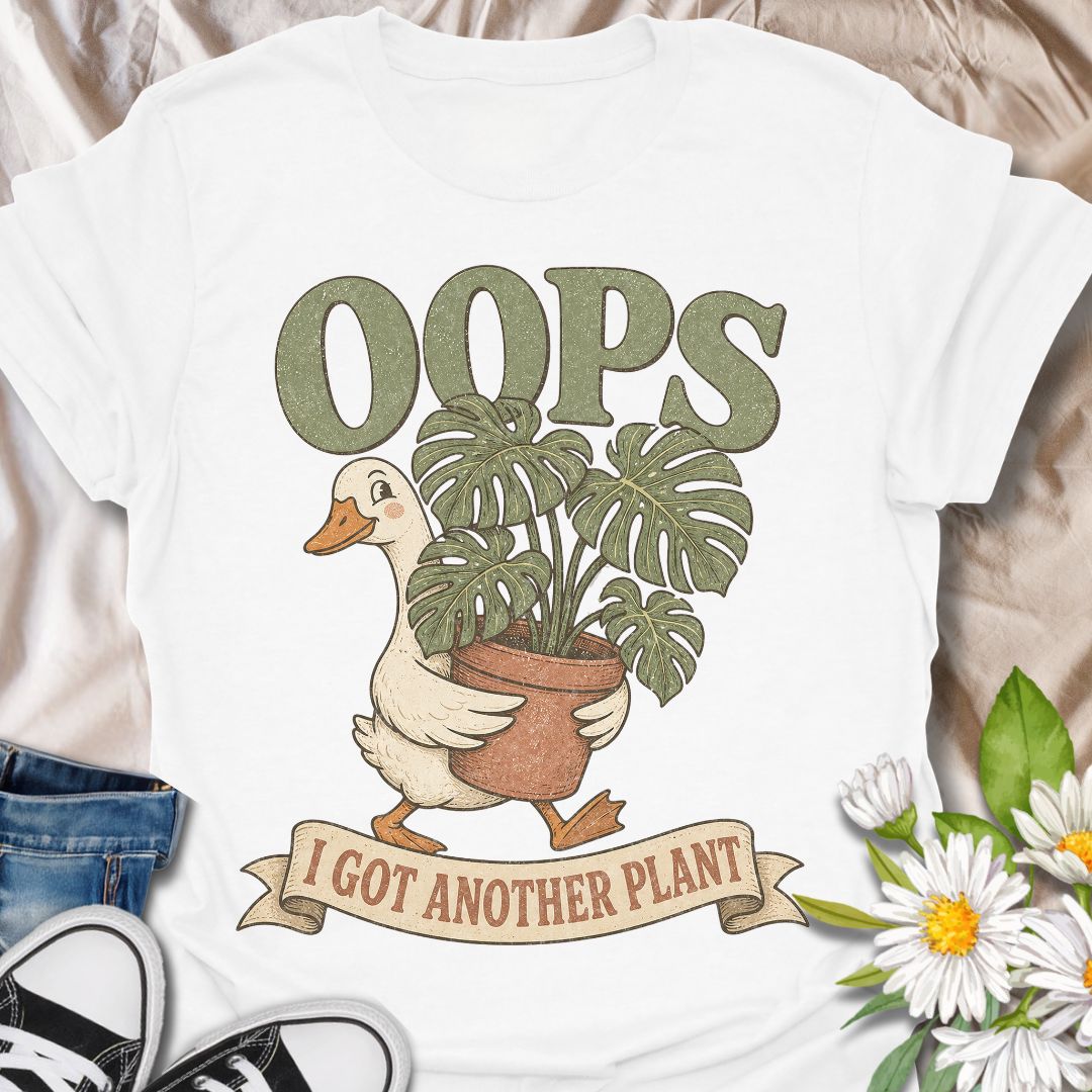 This Oops I Got Another Plant t-shirt is made for houseplant lovers who know exactly how one quick look at a plant shop turns into a new leafy addition. Featuring a cute goose carrying a potted monstera, bold retro lettering, and a playful banner design, this tee is funny, charming, and perfect for proud plant collectors. A great gift for plant moms, plant dads, indoor gardeners, propagation fans, monstera lovers, and anyone who always has room for just one more plant.