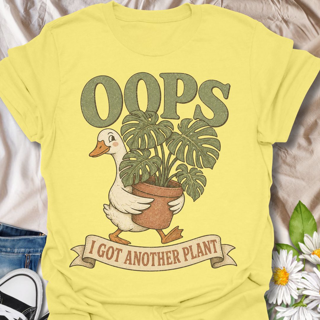 This Oops I Got Another Plant t-shirt is made for houseplant lovers who know exactly how one quick look at a plant shop turns into a new leafy addition. Featuring a cute goose carrying a potted monstera, bold retro lettering, and a playful banner design, this tee is funny, charming, and perfect for proud plant collectors. A great gift for plant moms, plant dads, indoor gardeners, propagation fans, monstera lovers, and anyone who always has room for just one more plant.