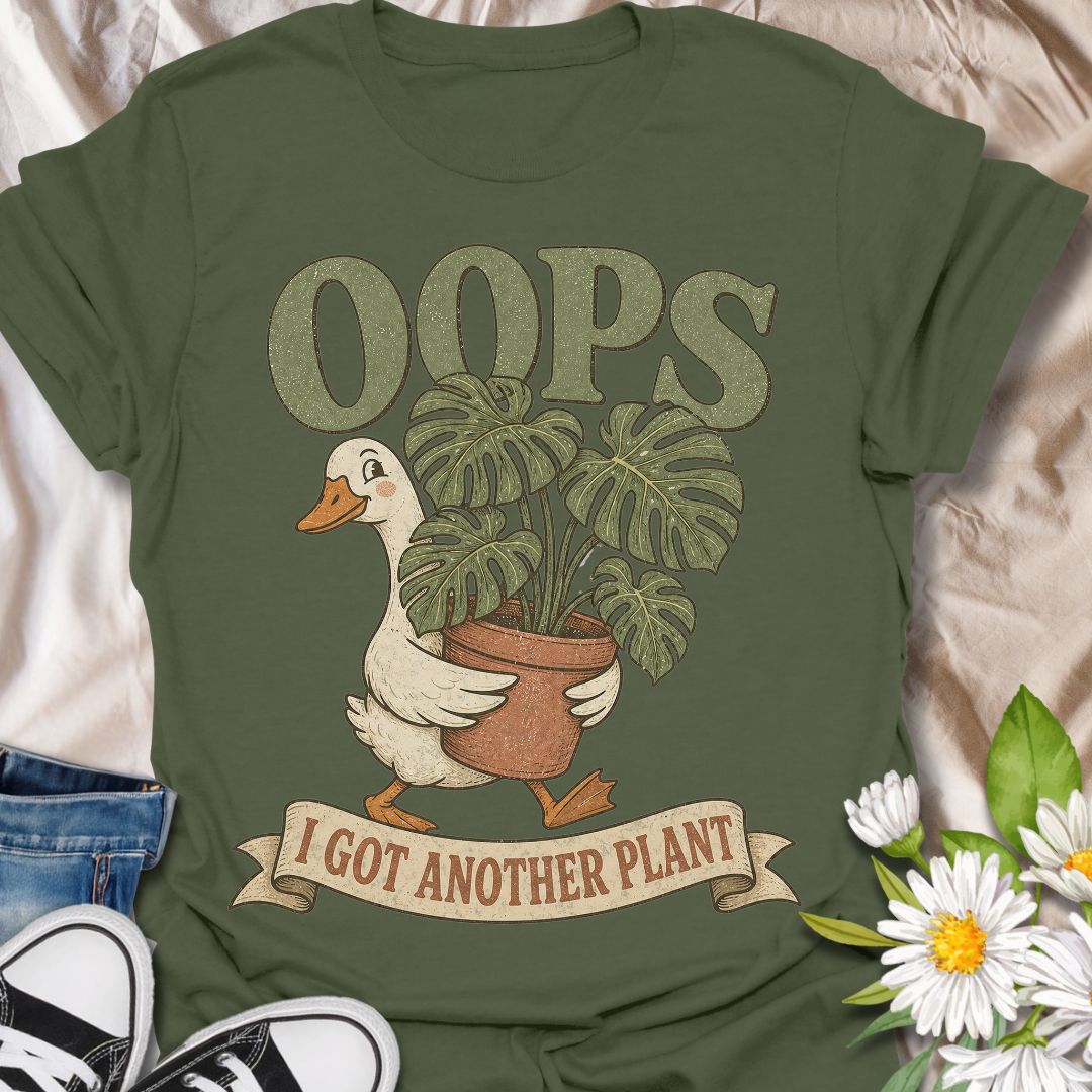 This Oops I Got Another Plant t-shirt is made for houseplant lovers who know exactly how one quick look at a plant shop turns into a new leafy addition. Featuring a cute goose carrying a potted monstera, bold retro lettering, and a playful banner design, this tee is funny, charming, and perfect for proud plant collectors. A great gift for plant moms, plant dads, indoor gardeners, propagation fans, monstera lovers, and anyone who always has room for just one more plant.