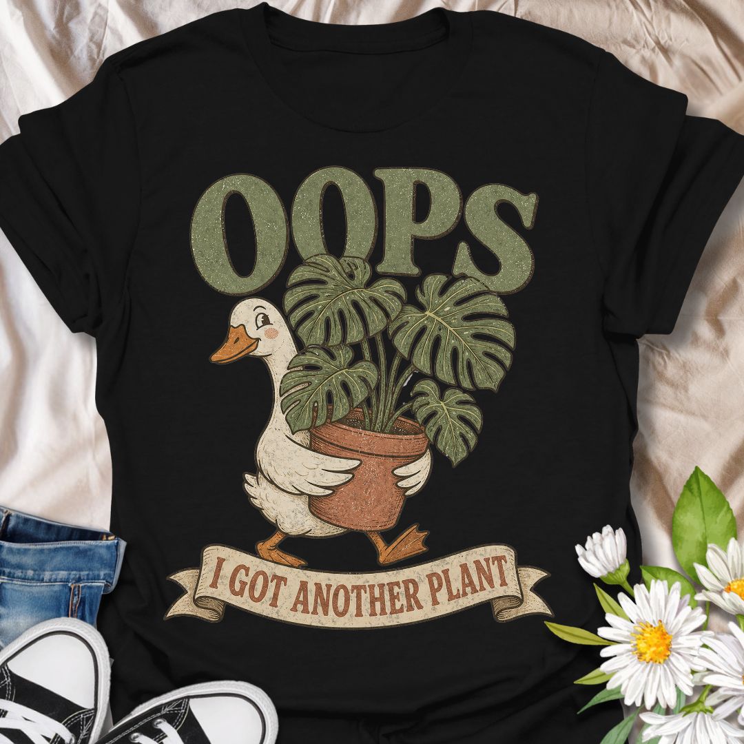 This Oops I Got Another Plant t-shirt is made for houseplant lovers who know exactly how one quick look at a plant shop turns into a new leafy addition. Featuring a cute goose carrying a potted monstera, bold retro lettering, and a playful banner design, this tee is funny, charming, and perfect for proud plant collectors. A great gift for plant moms, plant dads, indoor gardeners, propagation fans, monstera lovers, and anyone who always has room for just one more plant.