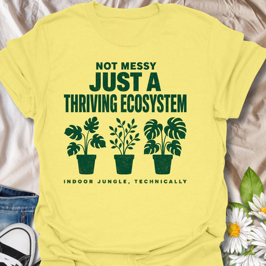 This Not Messy Just A Thriving Ecosystem t-shirt is made for houseplant lovers whose indoor jungle has officially taken over the room. Featuring bold green typography, potted plant silhouettes, monstera leaves, and the phrase indoor jungle, technically, this design is funny, relatable, and perfect for proud plant collectors. A great gift for plant moms, plant dads, houseplant lovers, indoor gardeners, and anyone who knows a few extra plants absolutely counts as an ecosystem.