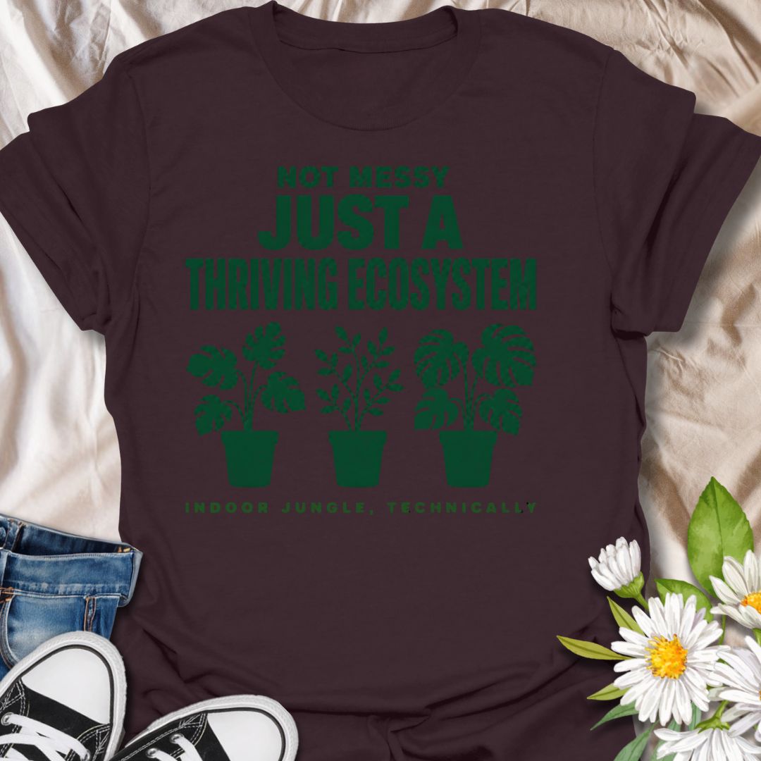 This Not Messy Just A Thriving Ecosystem t-shirt is made for houseplant lovers whose indoor jungle has officially taken over the room. Featuring bold green typography, potted plant silhouettes, monstera leaves, and the phrase indoor jungle, technically, this design is funny, relatable, and perfect for proud plant collectors. A great gift for plant moms, plant dads, houseplant lovers, indoor gardeners, and anyone who knows a few extra plants absolutely counts as an ecosystem.