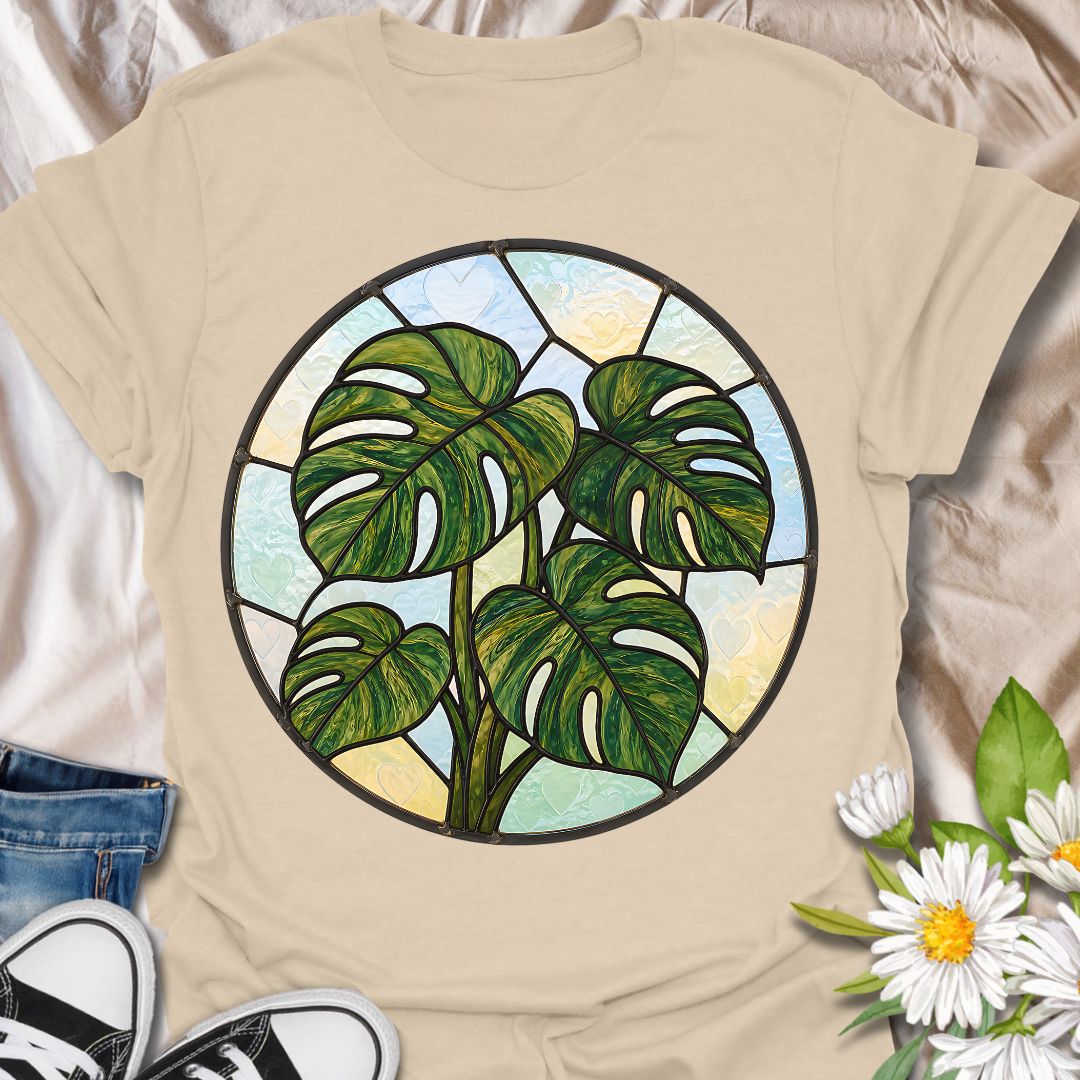 This Stained Glass Monstera t-shirt is made for houseplant lovers who want a bold, artistic take on their favorite leafy plant. Featuring a circular stained-glass style monstera design with rich green leaves, dark lead-line details, and soft pastel glass panels, this tee has a beautiful botanical look that feels unique and eye-catching. Perfect for plant moms, plant dads, monstera lovers, houseplant collectors, indoor gardeners, and anyone who loves statement plant artwork.