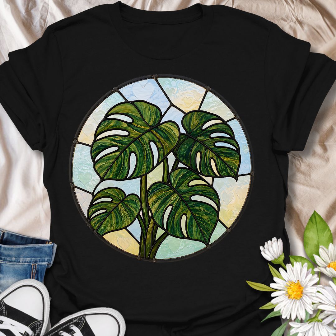 This Stained Glass Monstera t-shirt is made for houseplant lovers who want a bold, artistic take on their favorite leafy plant. Featuring a circular stained-glass style monstera design with rich green leaves, dark lead-line details, and soft pastel glass panels, this tee has a beautiful botanical look that feels unique and eye-catching. Perfect for plant moms, plant dads, monstera lovers, houseplant collectors, indoor gardeners, and anyone who loves statement plant artwork.