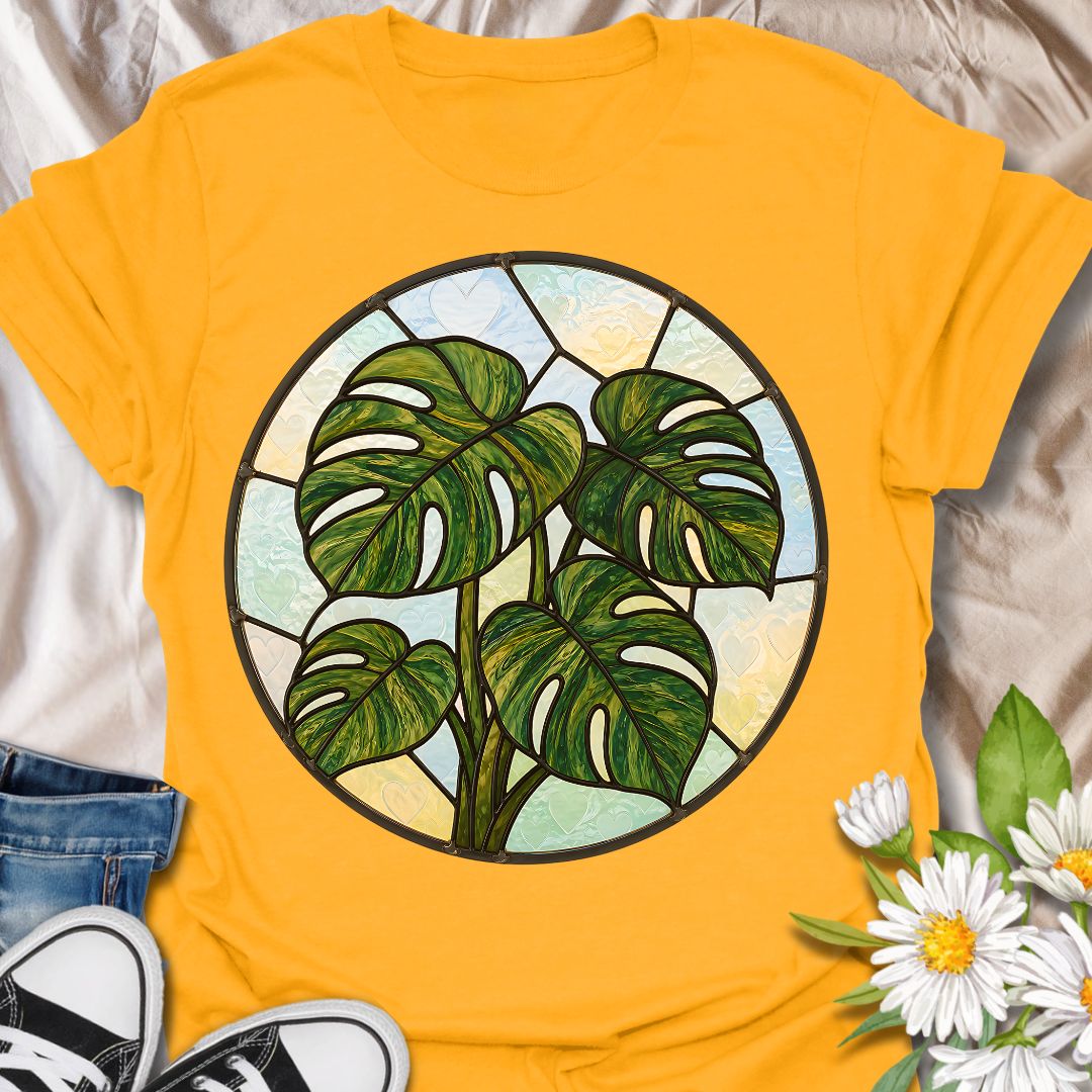 This Stained Glass Monstera t-shirt is made for houseplant lovers who want a bold, artistic take on their favorite leafy plant. Featuring a circular stained-glass style monstera design with rich green leaves, dark lead-line details, and soft pastel glass panels, this tee has a beautiful botanical look that feels unique and eye-catching. Perfect for plant moms, plant dads, monstera lovers, houseplant collectors, indoor gardeners, and anyone who loves statement plant artwork.