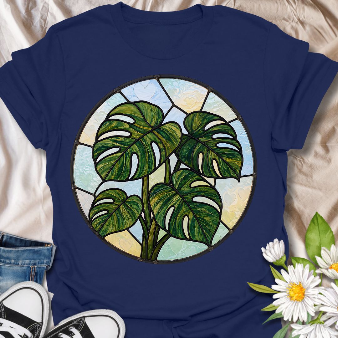 This Stained Glass Monstera t-shirt is made for houseplant lovers who want a bold, artistic take on their favorite leafy plant. Featuring a circular stained-glass style monstera design with rich green leaves, dark lead-line details, and soft pastel glass panels, this tee has a beautiful botanical look that feels unique and eye-catching. Perfect for plant moms, plant dads, monstera lovers, houseplant collectors, indoor gardeners, and anyone who loves statement plant artwork.