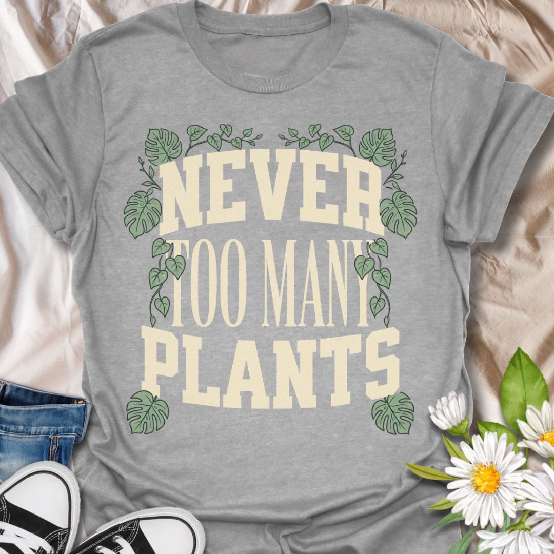 This Never Too Many Plants t-shirt is made for houseplant lovers who know there is always room for one more leafy friend. Featuring bold varsity-style lettering framed with monstera leaves and trailing vines, this design has a clean, statement botanical look for everyday plant-parent wear. Perfect for plant moms, plant dads, indoor gardeners, houseplant collectors, propagation fans, and anyone whose plant collection is never really finished.