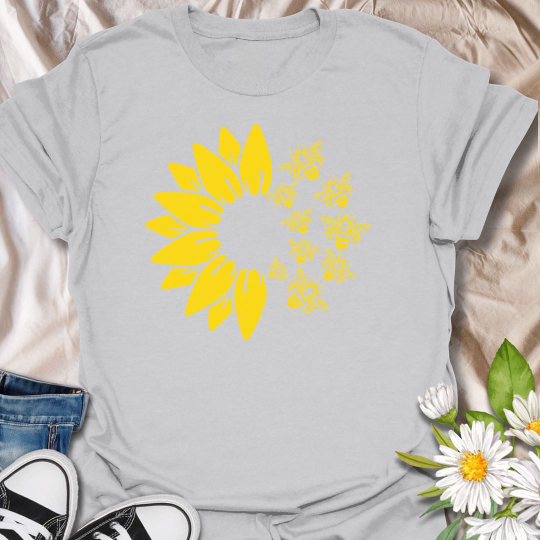 This Sunflower Bees t-shirt is made for nature lovers, gardeners, and pollinator fans who love bright sunny floral designs. Featuring a bold yellow sunflower with a swarm of buzzing bees, this simple single-colour design has a cheerful garden-inspired look that feels clean, fresh, and easy to wear. Perfect for bee lovers, sunflower fans, gardeners, wildflower lovers, pollinator supporters, and anyone who wants a happy nature-themed graphic tee.