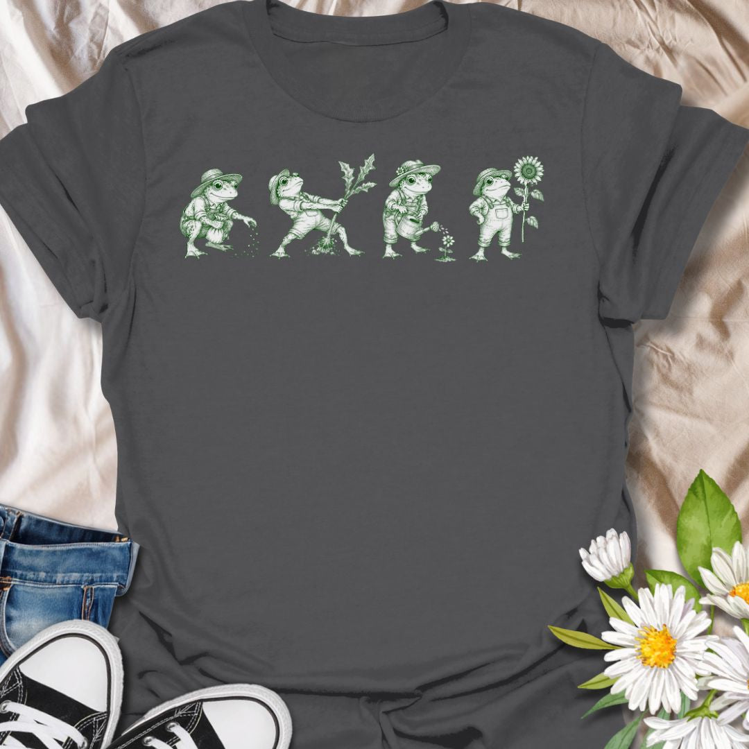 This Gardening Frogs t-shirt is made for plant lovers, gardeners, and frog fans who enjoy a whimsical nature-inspired design. Featuring four charming frogs doing garden tasks in a vintage green ink illustration style, this design has a playful cottagecore feel with plenty of botanical personality. Perfect for gardeners, plant moms, frog lovers, nature fans, cottagecore style lovers, and anyone who thinks gardening is better with a little amphibian charm.