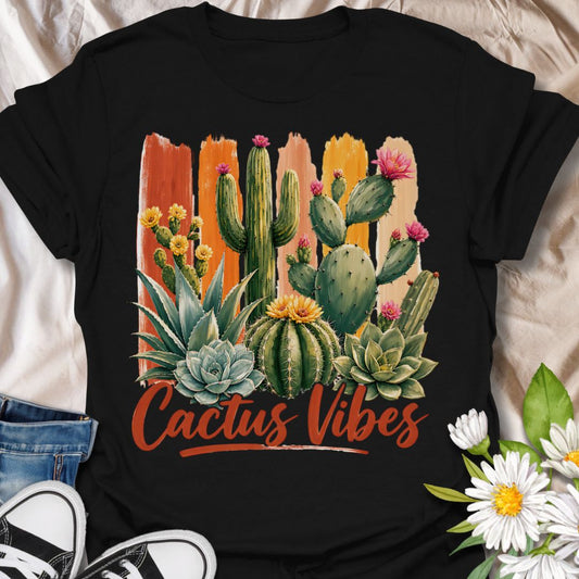 This Cactus Vibes t-shirt is made for plant lovers who are drawn to desert plants, succulents, and bold botanical artwork. Featuring a colorful cactus and succulent arrangement with painterly brushstroke accents, blooming prickly pear flowers, agave, and warm earthy lettering, this design has a bright southwestern garden feel. Perfect for cactus lovers, succulent fans, plant moms, plant dads, desert plant collectors, and anyone who loves relaxed plant vibes.