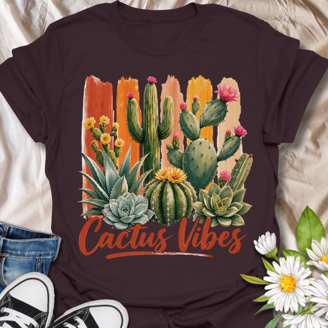 This Cactus Vibes t-shirt is made for plant lovers who are drawn to desert plants, succulents, and bold botanical artwork. Featuring a colorful cactus and succulent arrangement with painterly brushstroke accents, blooming prickly pear flowers, agave, and warm earthy lettering, this design has a bright southwestern garden feel. Perfect for cactus lovers, succulent fans, plant moms, plant dads, desert plant collectors, and anyone who loves relaxed plant vibes.