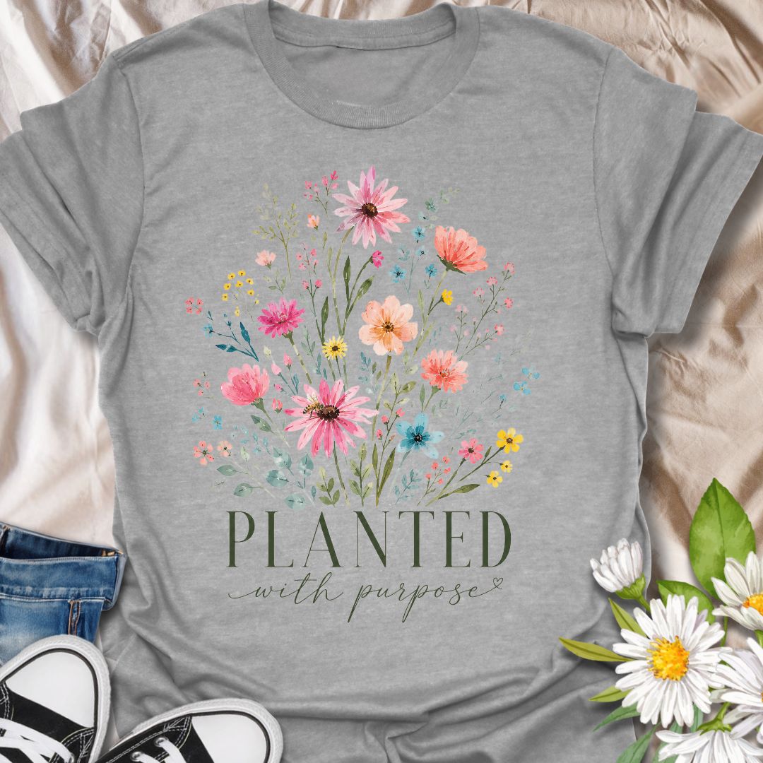 This Planted With Purpose t-shirt is made for flower lovers, gardeners, and anyone drawn to soft botanical designs with an uplifting message. Featuring a loose watercolor-style wildflower bouquet with pink, coral, yellow, blue, and sage green florals, this design has a feminine, graceful garden-inspired feel. Perfect for plant lovers, flower fans, gardeners, nature lovers, and anyone who loves meaningful floral artwork with a calm, pretty style.