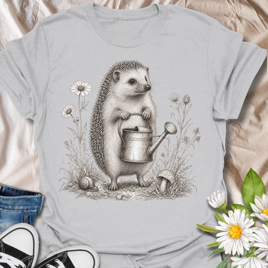 This Hedgehog Gardener t-shirt is made for gardeners, nature lovers, and woodland animal fans who enjoy soft vintage-style artwork. Featuring a sweet hedgehog holding a watering can, surrounded by wildflowers, grass, a snail, and a tiny mushroom, this design has a charming cottagecore garden feel. Perfect for gardeners, plant lovers, hedgehog fans, wildlife lovers, botanical art fans, and anyone who loves gentle nature-inspired designs.