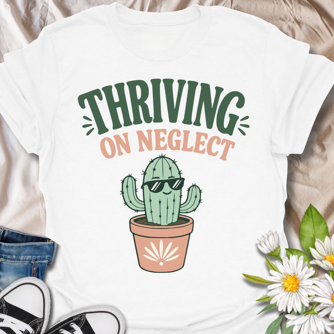 This Thriving On Neglect t-shirt is made for plant lovers who relate a little too much to low-maintenance cactus energy. Featuring a cool potted cactus wearing sunglasses with bold retro lettering in green, peach, and soft cream, this design has a funny, easygoing botanical vibe. Perfect for cactus lovers, succulent fans, plant moms, plant dads, houseplant collectors, and anyone who is doing surprisingly well with minimal care.