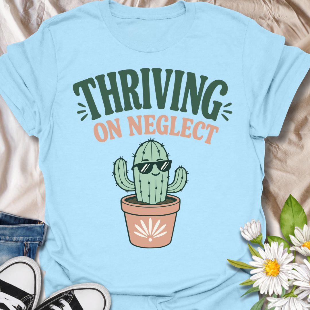 This Thriving On Neglect t-shirt is made for plant lovers who relate a little too much to low-maintenance cactus energy. Featuring a cool potted cactus wearing sunglasses with bold retro lettering in green, peach, and soft cream, this design has a funny, easygoing botanical vibe. Perfect for cactus lovers, succulent fans, plant moms, plant dads, houseplant collectors, and anyone who is doing surprisingly well with minimal care.