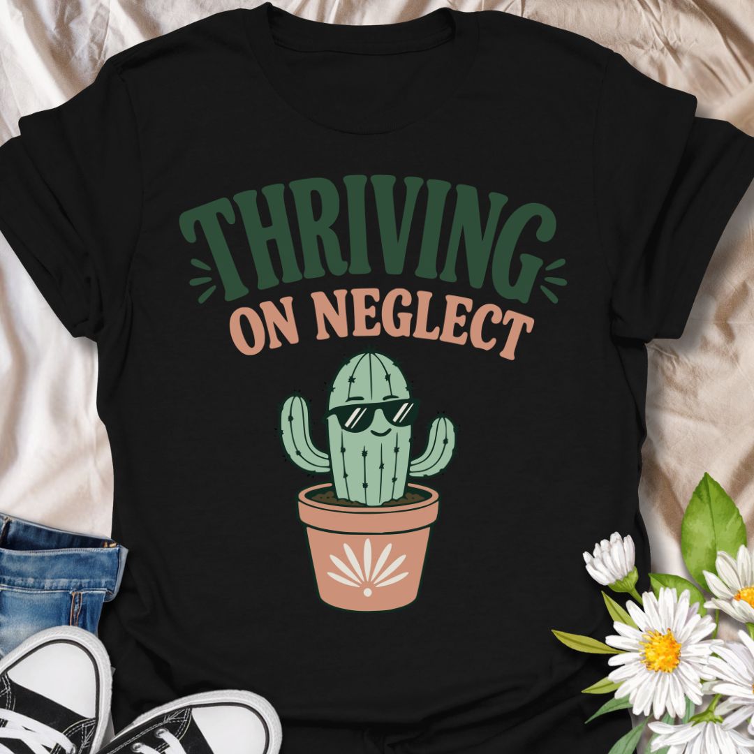 This Thriving On Neglect t-shirt is made for plant lovers who relate a little too much to low-maintenance cactus energy. Featuring a cool potted cactus wearing sunglasses with bold retro lettering in green, peach, and soft cream, this design has a funny, easygoing botanical vibe. Perfect for cactus lovers, succulent fans, plant moms, plant dads, houseplant collectors, and anyone who is doing surprisingly well with minimal care.
