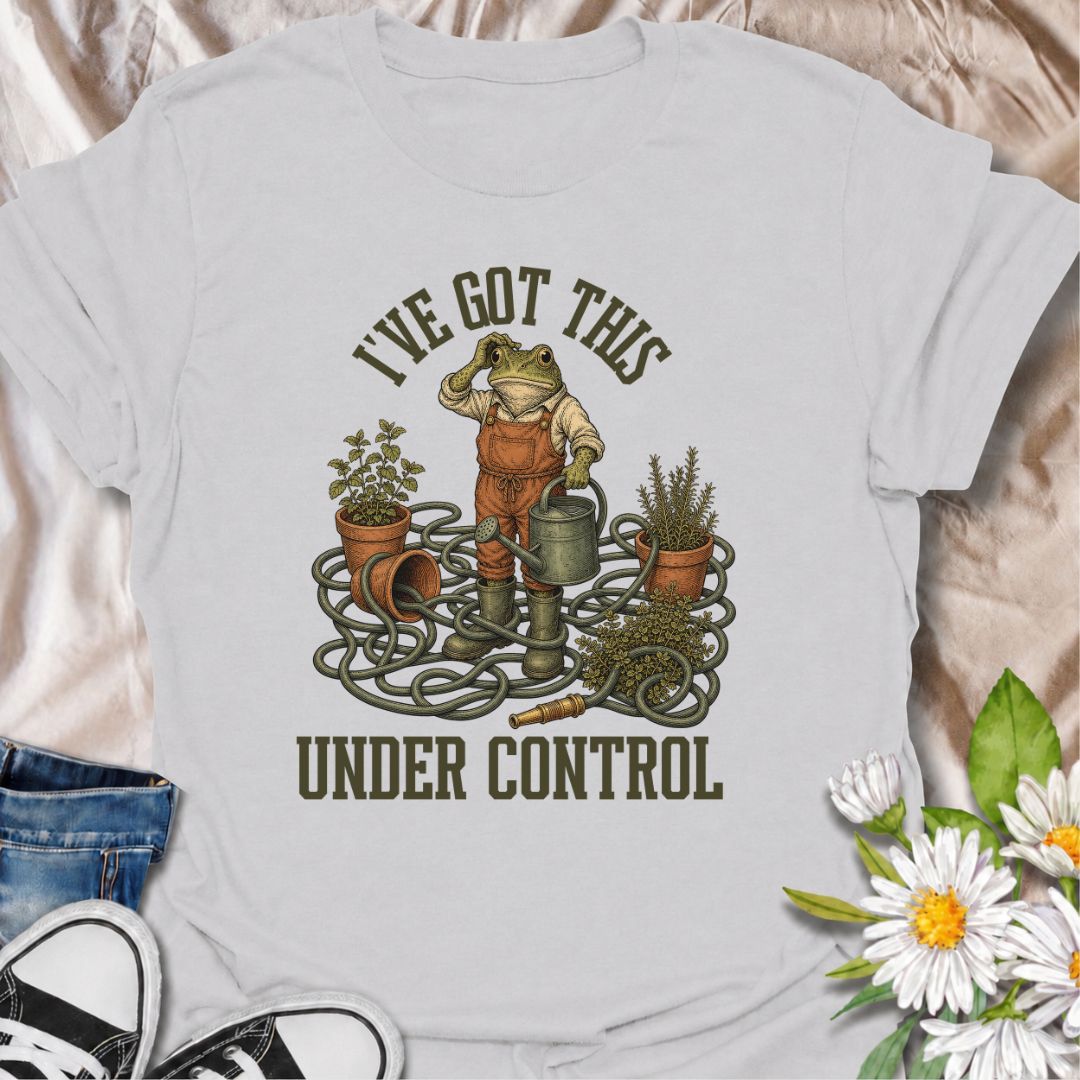 A funny gardening T-shirt for anyone who insists everything is completely under control, despite the evidence. Featuring a determined frog surrounded by tangled hose, pots, herbs, and garden tools, this design is perfect for gardeners who know chaos is part of the process. The phrase “I’ve Got This Under Control” adds dry, relatable humor without making the design feel too busy. It makes a great gift for backyard gardeners, plant lovers, and anyone who spends weekends wrestling with watering cans, hoses, an
