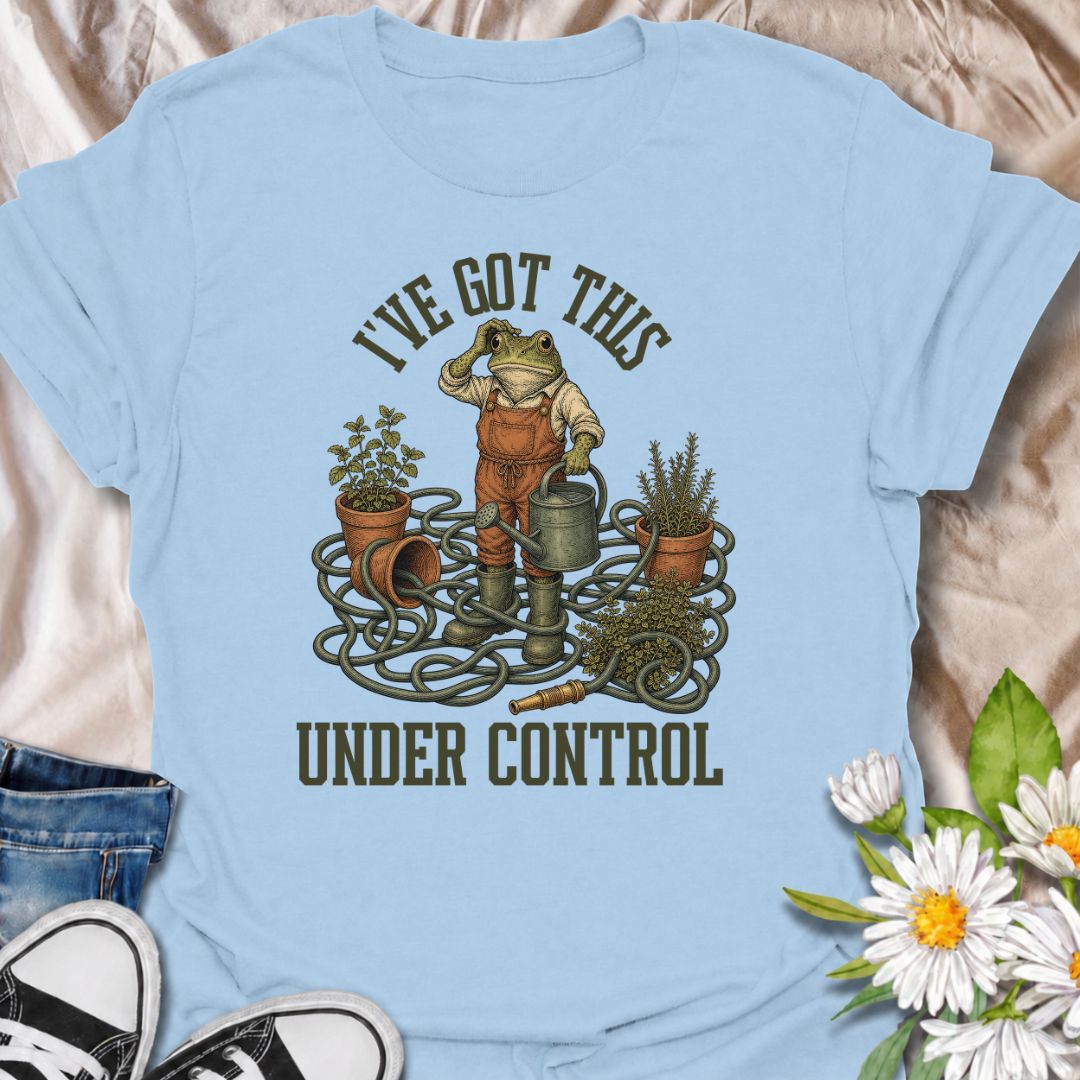 A funny gardening T-shirt for anyone who insists everything is completely under control, despite the evidence. Featuring a determined frog surrounded by tangled hose, pots, herbs, and garden tools, this design is perfect for gardeners who know chaos is part of the process. The phrase “I’ve Got This Under Control” adds dry, relatable humor without making the design feel too busy. It makes a great gift for backyard gardeners, plant lovers, and anyone who spends weekends wrestling with watering cans, hoses, an