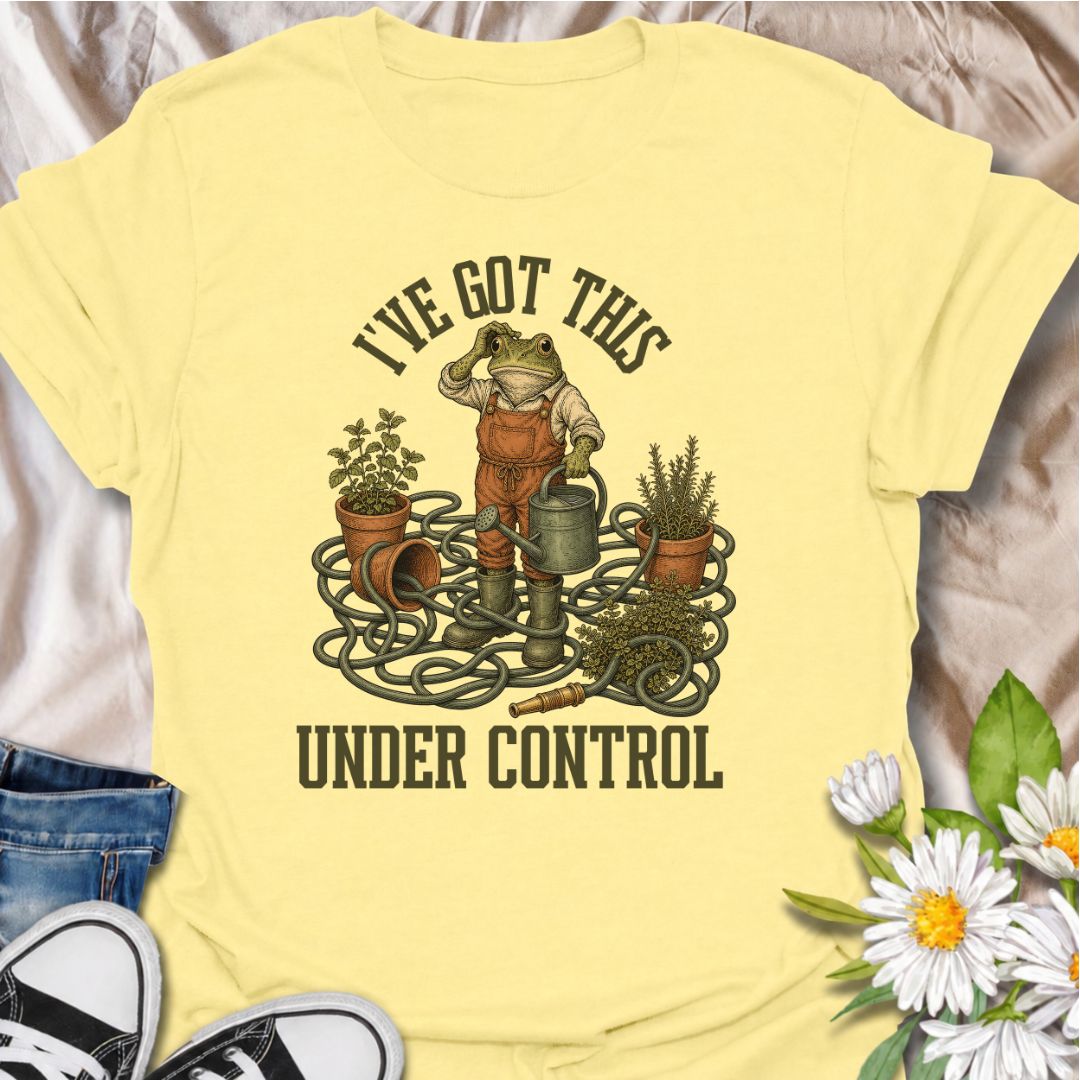 A funny gardening T-shirt for anyone who insists everything is completely under control, despite the evidence. Featuring a determined frog surrounded by tangled hose, pots, herbs, and garden tools, this design is perfect for gardeners who know chaos is part of the process. The phrase “I’ve Got This Under Control” adds dry, relatable humor without making the design feel too busy. It makes a great gift for backyard gardeners, plant lovers, and anyone who spends weekends wrestling with watering cans, hoses, an