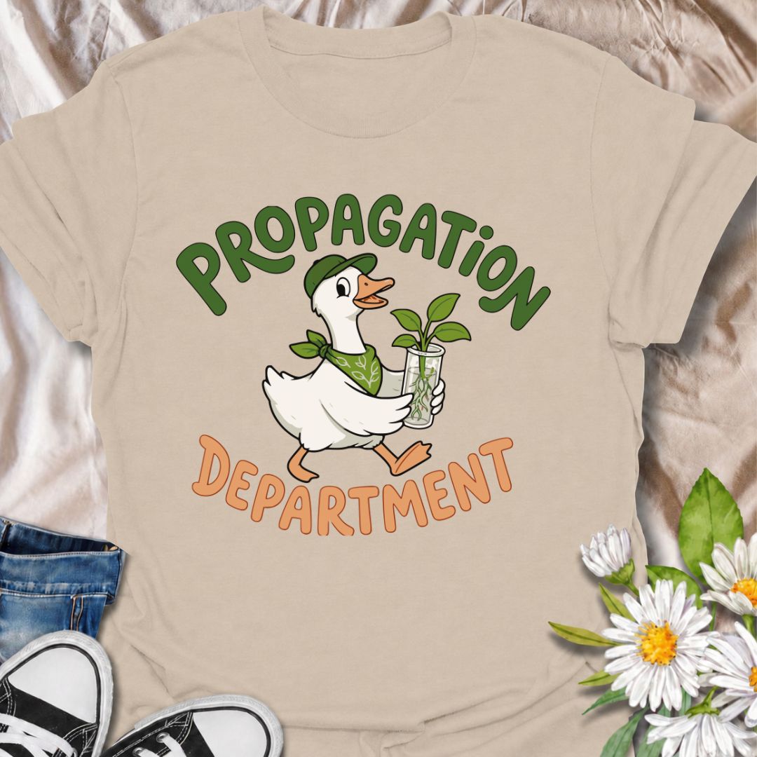 A funny propagation T-shirt for plant lovers who treat rooting cuttings like a proper department of operations. Featuring a cheerful goose carrying a fresh plant cutting in water, this design is perfect for houseplant collectors, plant parents, and propagation fans. The “Propagation Department” phrase gives the design a playful club-style feel without losing its clean, easy-to-read look. It makes a great gift for pothos lovers, indoor gardeners, and anyone with jars of cuttings taking over the counter. Idea