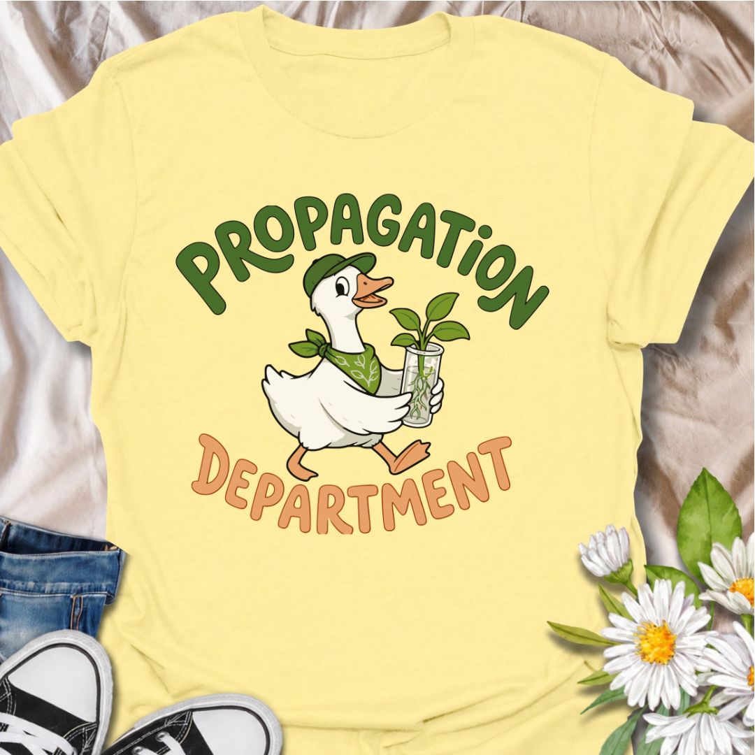 A funny propagation T-shirt for plant lovers who treat rooting cuttings like a proper department of operations. Featuring a cheerful goose carrying a fresh plant cutting in water, this design is perfect for houseplant collectors, plant parents, and propagation fans. The “Propagation Department” phrase gives the design a playful club-style feel without losing its clean, easy-to-read look. It makes a great gift for pothos lovers, indoor gardeners, and anyone with jars of cuttings taking over the counter. Idea