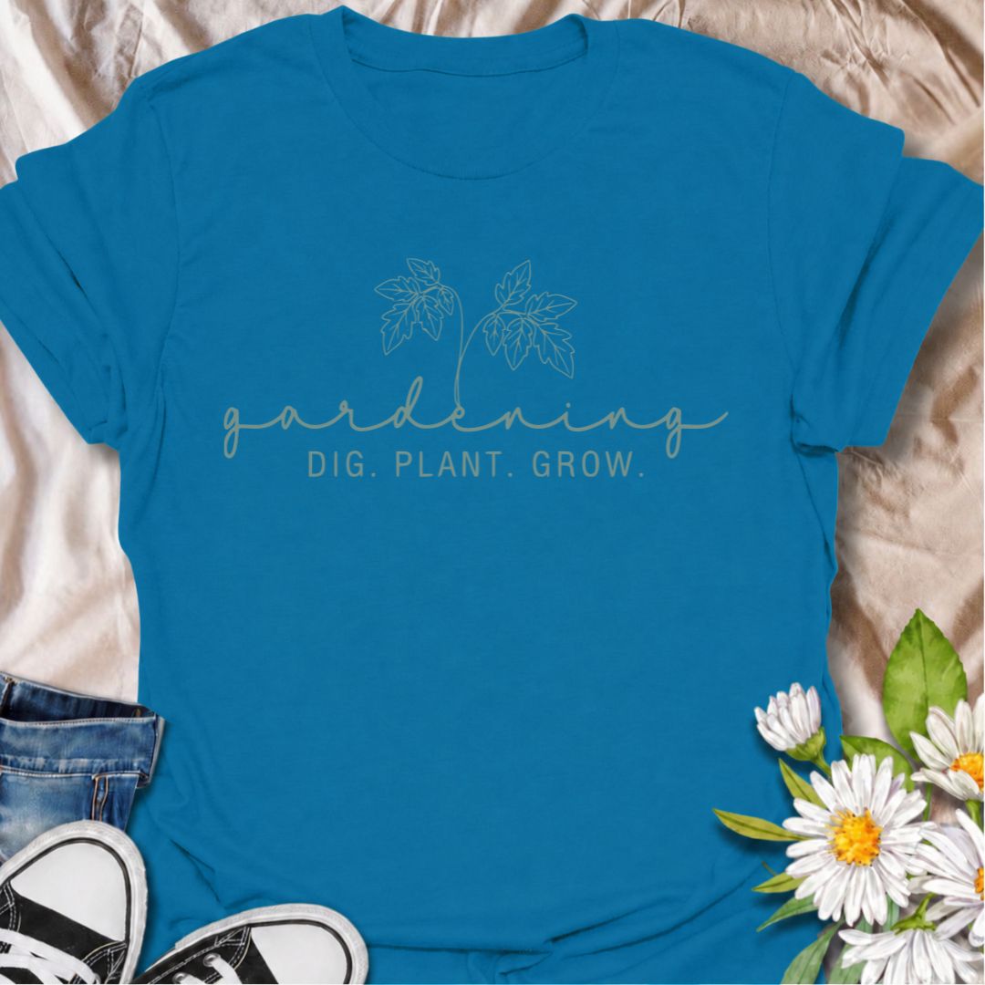 A simple gardening T-shirt for anyone who feels most at home with their hands in the soil. The understated “Gardening — Dig. Plant. Grow.” design combines delicate botanical line art with a clean, relaxed look. It is perfect for gardeners, plant lovers, backyard growers, and anyone who enjoys the quiet rhythm of planting and growing. The softer style makes it especially easy to wear while still clearly speaking to the gardening niche. A lovely gift for flower gardeners, vegetable growers, and anyone who wou