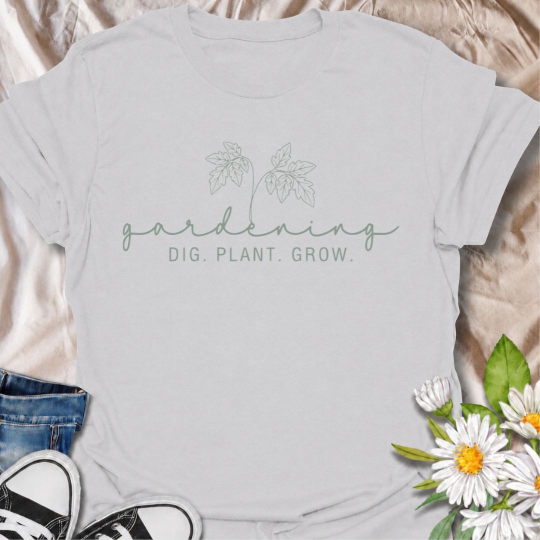 A simple gardening T-shirt for anyone who feels most at home with their hands in the soil. The understated “Gardening — Dig. Plant. Grow.” design combines delicate botanical line art with a clean, relaxed look. It is perfect for gardeners, plant lovers, backyard growers, and anyone who enjoys the quiet rhythm of planting and growing. The softer style makes it especially easy to wear while still clearly speaking to the gardening niche. A lovely gift for flower gardeners, vegetable growers, and anyone who wou