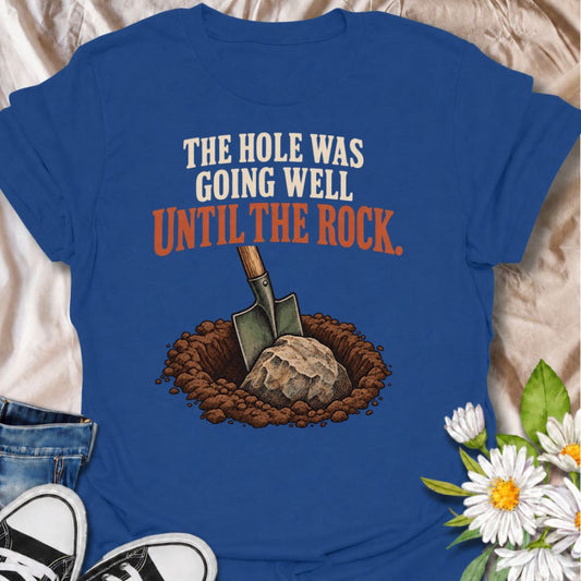 A funny gardening T-shirt for anyone who knows digging is easy right up until the shovel hits something solid. The phrase “The Hole Was Going Well Until the Rock” captures one of those instantly recognizable gardening frustrations with dry, relatable humor. Featuring a vintage-style shovel, soil, and one very inconvenient rock, this design is perfect for backyard gardeners, landscapers, and keen growers. It makes a great gift for gardeners who have battled stubborn ground, buried stones, and supposedly “qui