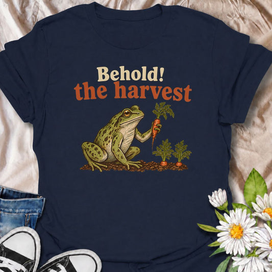 A funny gardening T-shirt for anyone who knows the pride of harvesting something tiny after weeks of effort. Featuring a very pleased frog proudly presenting a carrot, this design captures the humor of homegrown vegetables perfectly. The phrase “Behold! The Harvest” makes it ideal for vegetable gardeners, backyard growers, and anyone who celebrates every little garden success. It is a fun gift for carrot growers, allotment gardeners, and people who love playful garden humor. Perfect for harvest season, gard