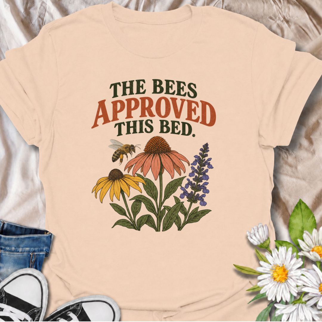 A cheerful gardening T-shirt for anyone who takes pride in growing flowers the pollinators love. The phrase “The Bees Approved This Bed” pairs perfectly with coneflowers, black-eyed Susans, salvia, and a visiting bee for a garden design with real pollinator appeal. It is ideal for flower gardeners, wildlife gardeners, native plant lovers, and anyone creating a bee-friendly backyard. The design makes a lovely gift for gardeners who enjoy supporting bees while filling their beds with color. Perfect for garden