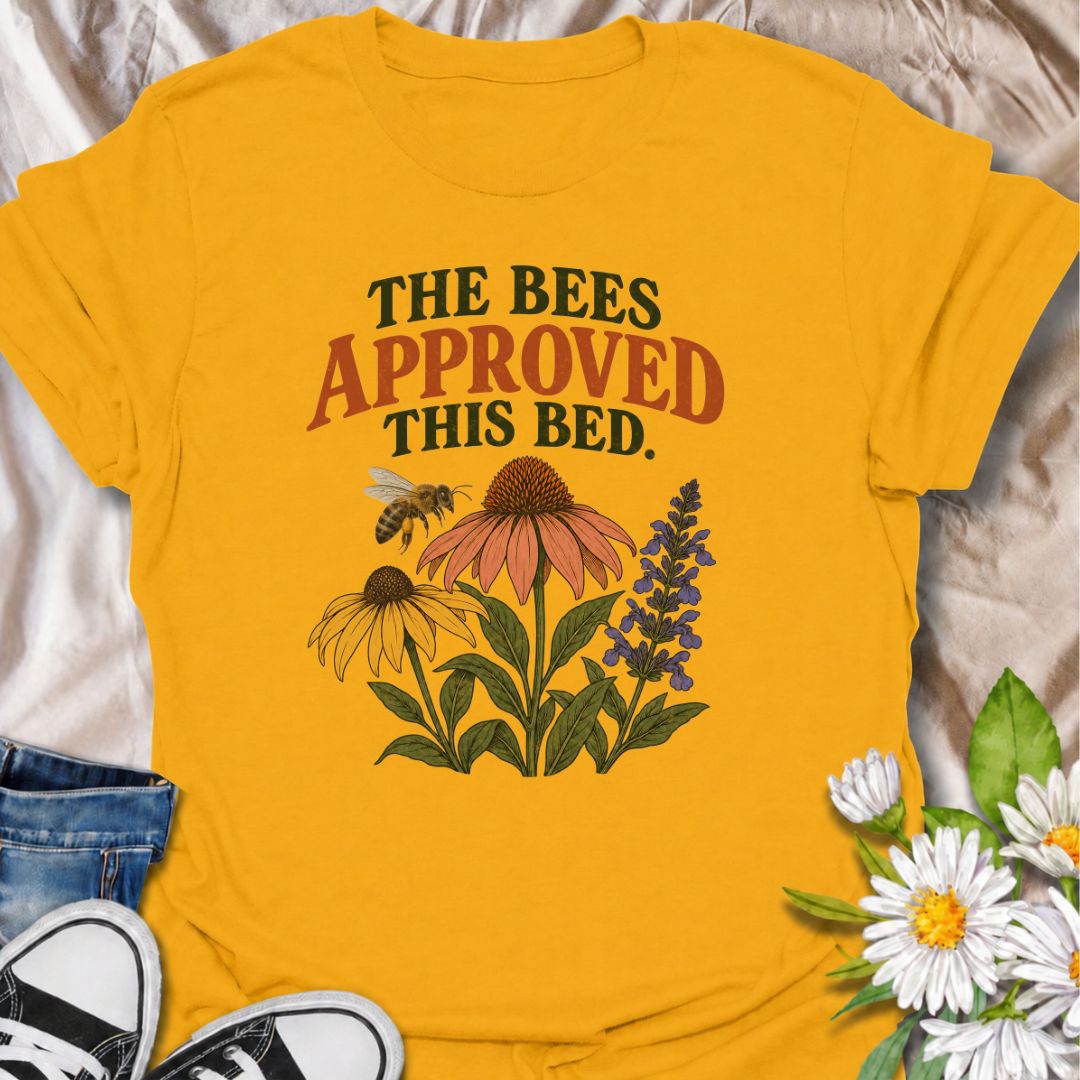 A cheerful gardening T-shirt for anyone who takes pride in growing flowers the pollinators love. The phrase “The Bees Approved This Bed” pairs perfectly with coneflowers, black-eyed Susans, salvia, and a visiting bee for a garden design with real pollinator appeal. It is ideal for flower gardeners, wildlife gardeners, native plant lovers, and anyone creating a bee-friendly backyard. The design makes a lovely gift for gardeners who enjoy supporting bees while filling their beds with color. Perfect for garden