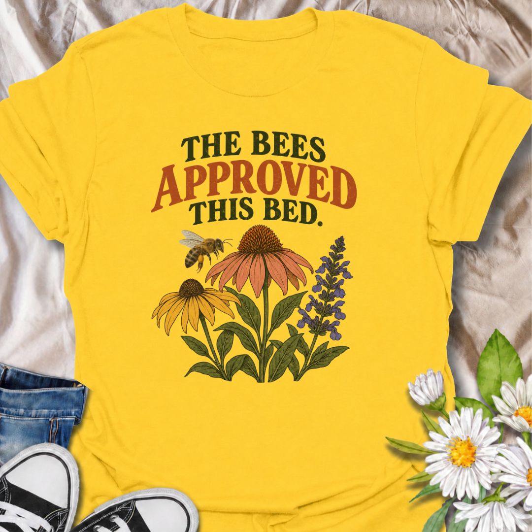 A cheerful gardening T-shirt for anyone who takes pride in growing flowers the pollinators love. The phrase “The Bees Approved This Bed” pairs perfectly with coneflowers, black-eyed Susans, salvia, and a visiting bee for a garden design with real pollinator appeal. It is ideal for flower gardeners, wildlife gardeners, native plant lovers, and anyone creating a bee-friendly backyard. The design makes a lovely gift for gardeners who enjoy supporting bees while filling their beds with color. Perfect for garden