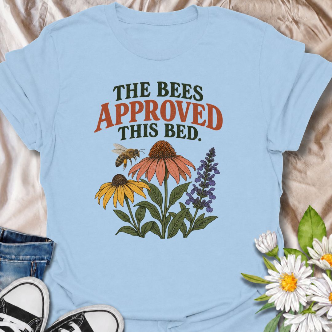A cheerful gardening T-shirt for anyone who takes pride in growing flowers the pollinators love. The phrase “The Bees Approved This Bed” pairs perfectly with coneflowers, black-eyed Susans, salvia, and a visiting bee for a garden design with real pollinator appeal. It is ideal for flower gardeners, wildlife gardeners, native plant lovers, and anyone creating a bee-friendly backyard. The design makes a lovely gift for gardeners who enjoy supporting bees while filling their beds with color. Perfect for garden