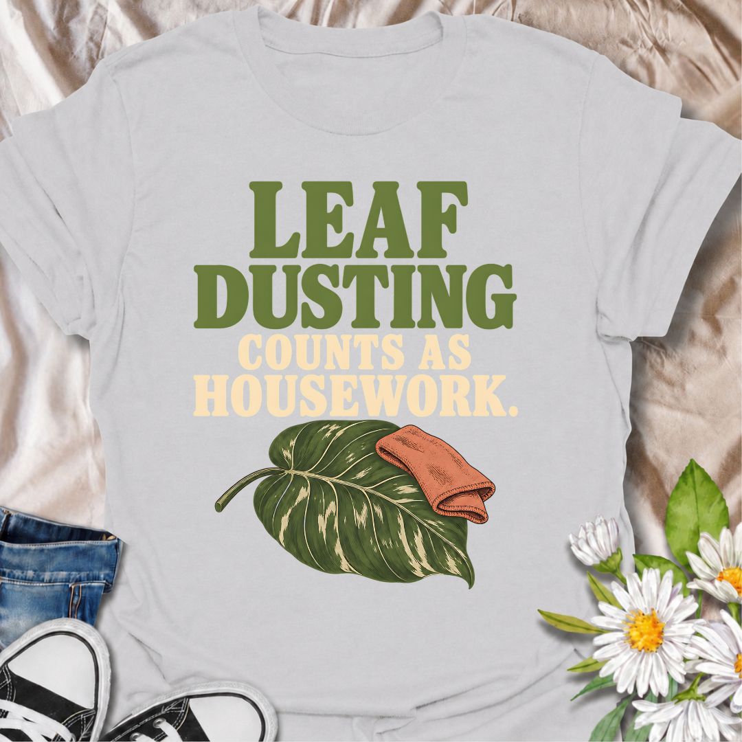 A funny houseplant T-shirt for anyone who insists that cleaning leaves absolutely counts as housework. The phrase “Leaf Dusting Counts as Housework” captures a very specific bit of plant-parent logic that houseplant lovers will instantly recognize. Featuring a large leafy plant and cleaning cloth, the design keeps the joke simple, niche, and easy to wear. It makes a great gift for plant collectors, indoor gardeners, and anyone who spends more time caring for leaves than doing ordinary chores. Ideal for plan