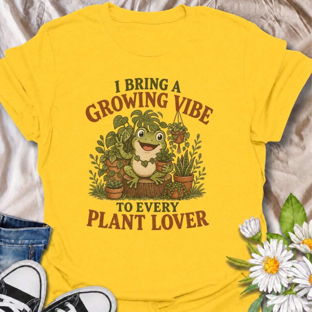 A playful plant T-shirt for anyone who brings cheerful energy wherever the houseplants are. Featuring a happy frog surrounded by lush potted plants, the phrase “I Bring a Growing Vibe to Every Plant Lover” gives the design a fun, lighthearted botanical feel. It is perfect for plant parents, houseplant collectors, indoor gardeners, and frog lovers alike. The colorful character-led artwork makes it a great gift for anyone building their own indoor jungle. Ideal for nursery trips, plant swaps, greenhouse days,