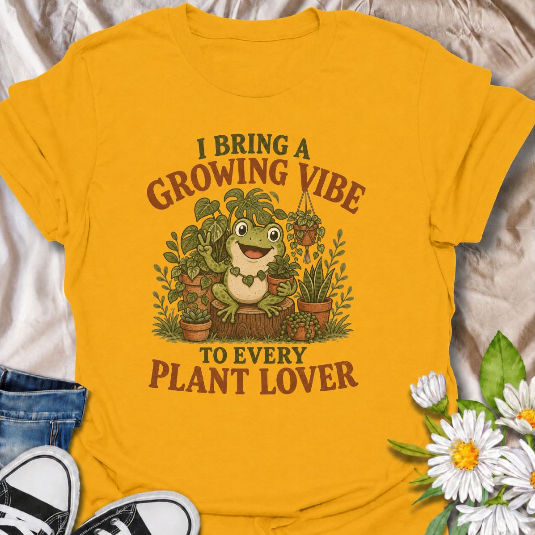 A playful plant T-shirt for anyone who brings cheerful energy wherever the houseplants are. Featuring a happy frog surrounded by lush potted plants, the phrase “I Bring a Growing Vibe to Every Plant Lover” gives the design a fun, lighthearted botanical feel. It is perfect for plant parents, houseplant collectors, indoor gardeners, and frog lovers alike. The colorful character-led artwork makes it a great gift for anyone building their own indoor jungle. Ideal for nursery trips, plant swaps, greenhouse days,