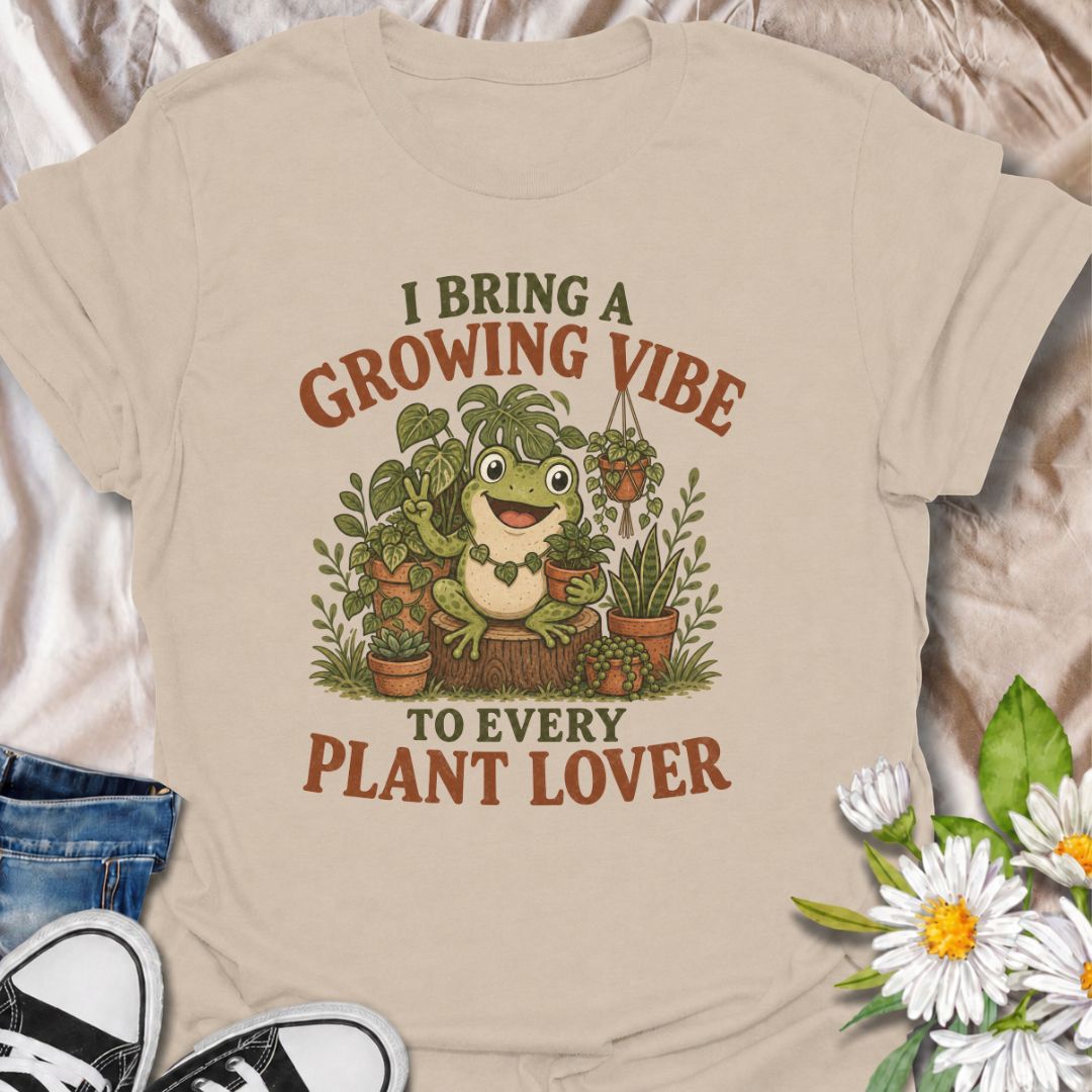 A playful plant T-shirt for anyone who brings cheerful energy wherever the houseplants are. Featuring a happy frog surrounded by lush potted plants, the phrase “I Bring a Growing Vibe to Every Plant Lover” gives the design a fun, lighthearted botanical feel. It is perfect for plant parents, houseplant collectors, indoor gardeners, and frog lovers alike. The colorful character-led artwork makes it a great gift for anyone building their own indoor jungle. Ideal for nursery trips, plant swaps, greenhouse days,