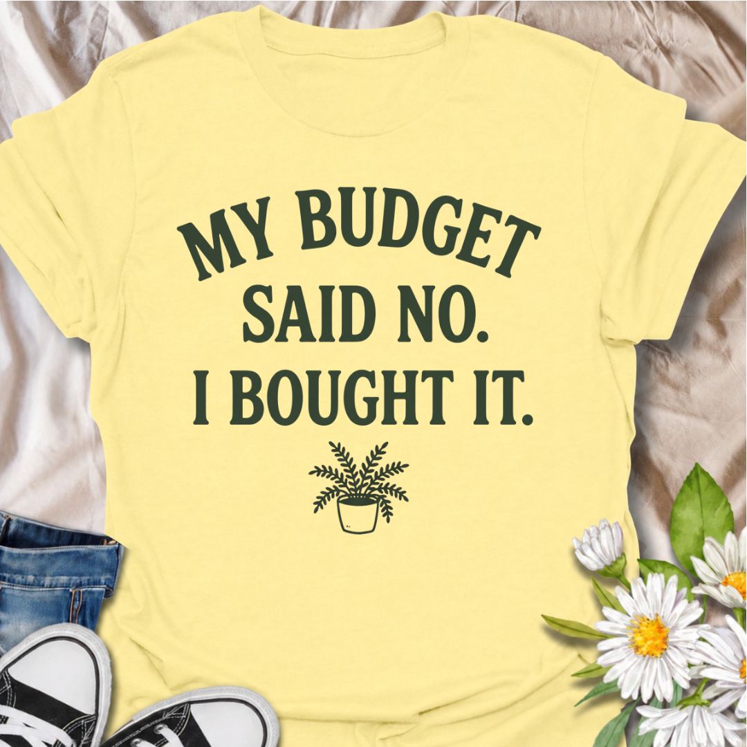 A funny plant T-shirt for anyone who knows a sensible budget can disappear the moment a new plant comes into view. The phrase “My Budget Said No. I Bought It.” captures the reality of impulsive plant shopping with simple, relatable humor. Featuring a small potted plant beneath bold retro typography, the design stays clean, readable, and easy to wear. It makes a great gift for plant parents, houseplant collectors, and nursery regulars who can never resist one more purchase. Perfect for plant swaps, garden ce