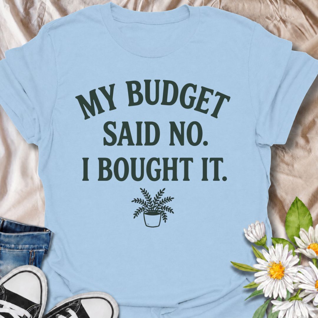 A funny plant T-shirt for anyone who knows a sensible budget can disappear the moment a new plant comes into view. The phrase “My Budget Said No. I Bought It.” captures the reality of impulsive plant shopping with simple, relatable humor. Featuring a small potted plant beneath bold retro typography, the design stays clean, readable, and easy to wear. It makes a great gift for plant parents, houseplant collectors, and nursery regulars who can never resist one more purchase. Perfect for plant swaps, garden ce