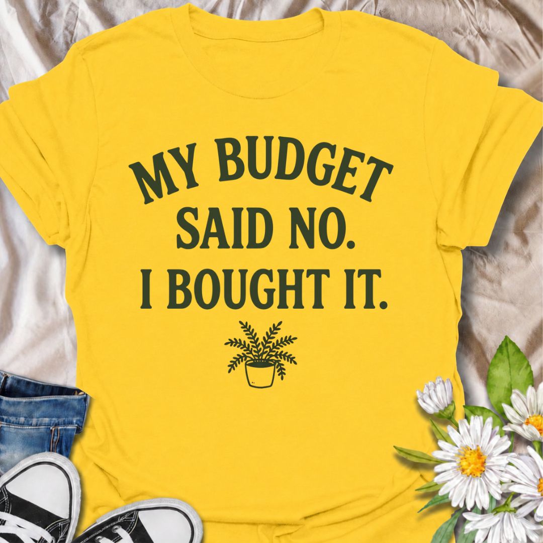 A funny plant T-shirt for anyone who knows a sensible budget can disappear the moment a new plant comes into view. The phrase “My Budget Said No. I Bought It.” captures the reality of impulsive plant shopping with simple, relatable humor. Featuring a small potted plant beneath bold retro typography, the design stays clean, readable, and easy to wear. It makes a great gift for plant parents, houseplant collectors, and nursery regulars who can never resist one more purchase. Perfect for plant swaps, garden ce