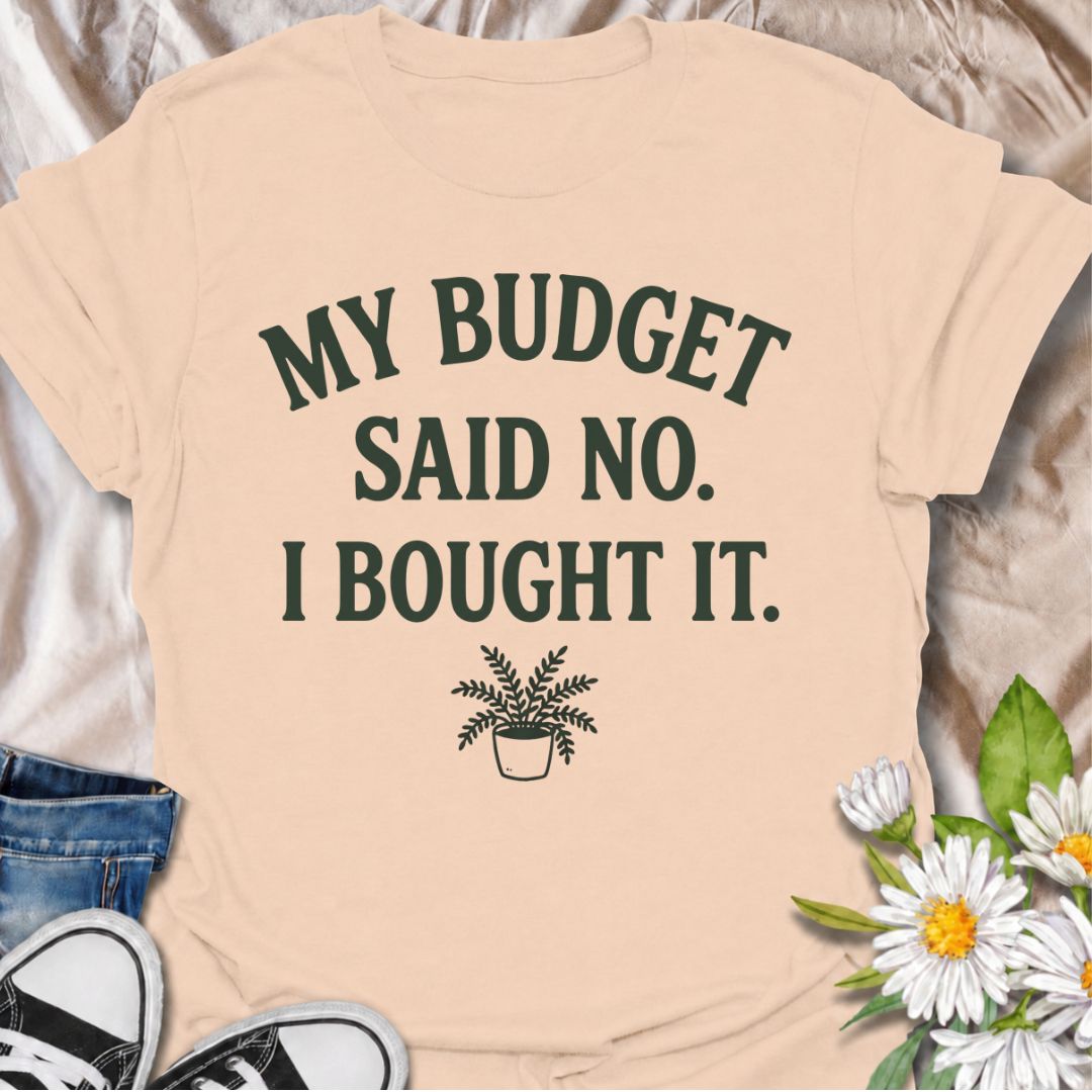 A funny plant T-shirt for anyone who knows a sensible budget can disappear the moment a new plant comes into view. The phrase “My Budget Said No. I Bought It.” captures the reality of impulsive plant shopping with simple, relatable humor. Featuring a small potted plant beneath bold retro typography, the design stays clean, readable, and easy to wear. It makes a great gift for plant parents, houseplant collectors, and nursery regulars who can never resist one more purchase. Perfect for plant swaps, garden ce