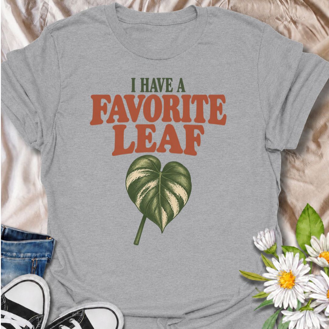 A playful plant T-shirt for anyone who definitely has a favorite leaf and is not afraid to admit it. The phrase “I Have a Favorite Leaf” pairs with a single variegated leaf for a simple, plant-lover design with just the right amount of personality. It is perfect for houseplant collectors, variegated plant fans, indoor gardeners, and anyone who notices every new leaf as it unfurls. The clean layout makes it easy to wear while still feeling distinctly niche. A great gift for plant parents, pothos lovers, phil