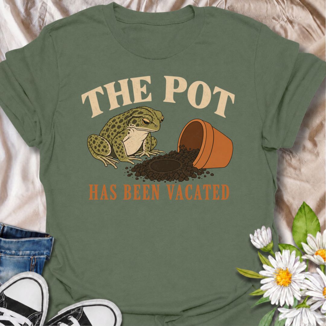 A funny plant T-shirt for anyone who knows an empty pot never stays empty for long. Featuring a deadpan frog beside an overturned planter and a suspiciously vacant patch of soil, this design gives “The Pot Has Been Vacated” a dry, slightly absurd sense of humor. It is perfect for houseplant lovers, plant parents, gardeners, and anyone who treats an empty pot as an invitation to buy something new. The vintage-style illustration makes it feel distinctive while still being easy to wear. A fun gift for plant co