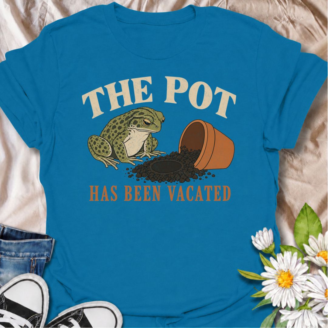 A funny plant T-shirt for anyone who knows an empty pot never stays empty for long. Featuring a deadpan frog beside an overturned planter and a suspiciously vacant patch of soil, this design gives “The Pot Has Been Vacated” a dry, slightly absurd sense of humor. It is perfect for houseplant lovers, plant parents, gardeners, and anyone who treats an empty pot as an invitation to buy something new. The vintage-style illustration makes it feel distinctive while still being easy to wear. A fun gift for plant co