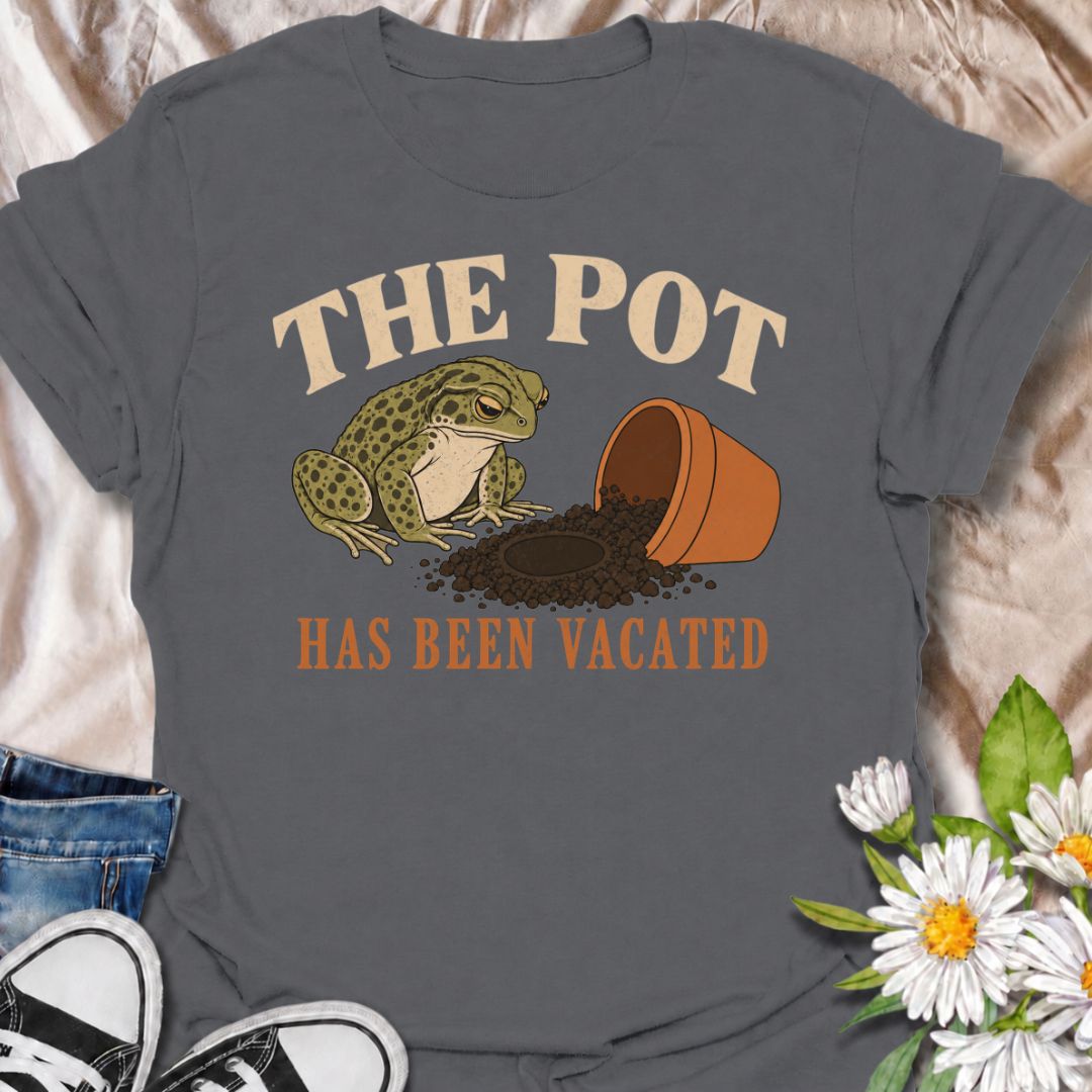 A funny plant T-shirt for anyone who knows an empty pot never stays empty for long. Featuring a deadpan frog beside an overturned planter and a suspiciously vacant patch of soil, this design gives “The Pot Has Been Vacated” a dry, slightly absurd sense of humor. It is perfect for houseplant lovers, plant parents, gardeners, and anyone who treats an empty pot as an invitation to buy something new. The vintage-style illustration makes it feel distinctive while still being easy to wear. A fun gift for plant co