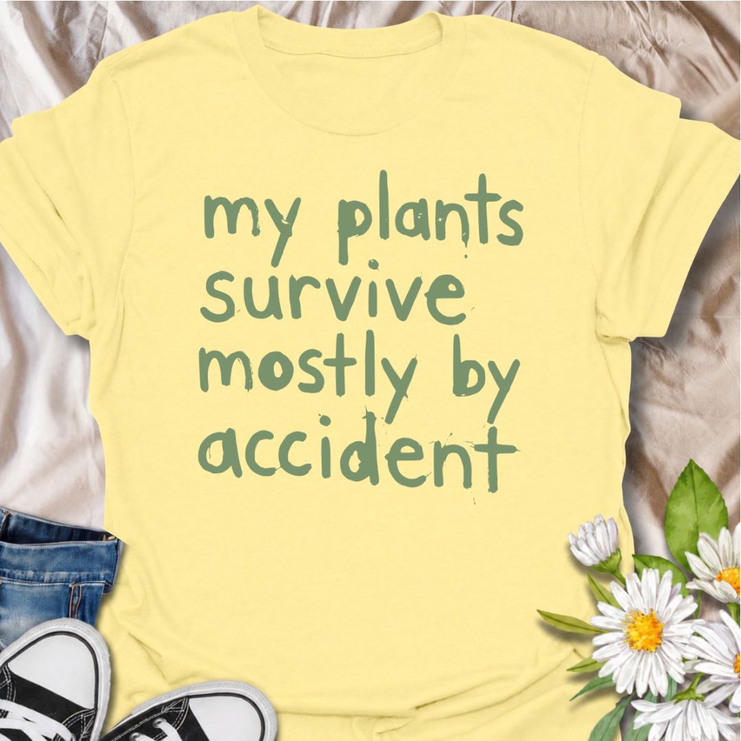A funny plant T-shirt for anyone whose houseplants are doing surprisingly well despite a slightly questionable care routine. The phrase “My Plants Survive Mostly by Accident” delivers dry, self-deprecating humor that plant parents and indoor gardeners will instantly relate to. Its simple hand-drawn typography keeps the design casual, modern, and easy to wear. It makes a great gift for houseplant lovers, accidental green thumbs, and anyone who is still figuring out what their plants actually need. Perfect fo