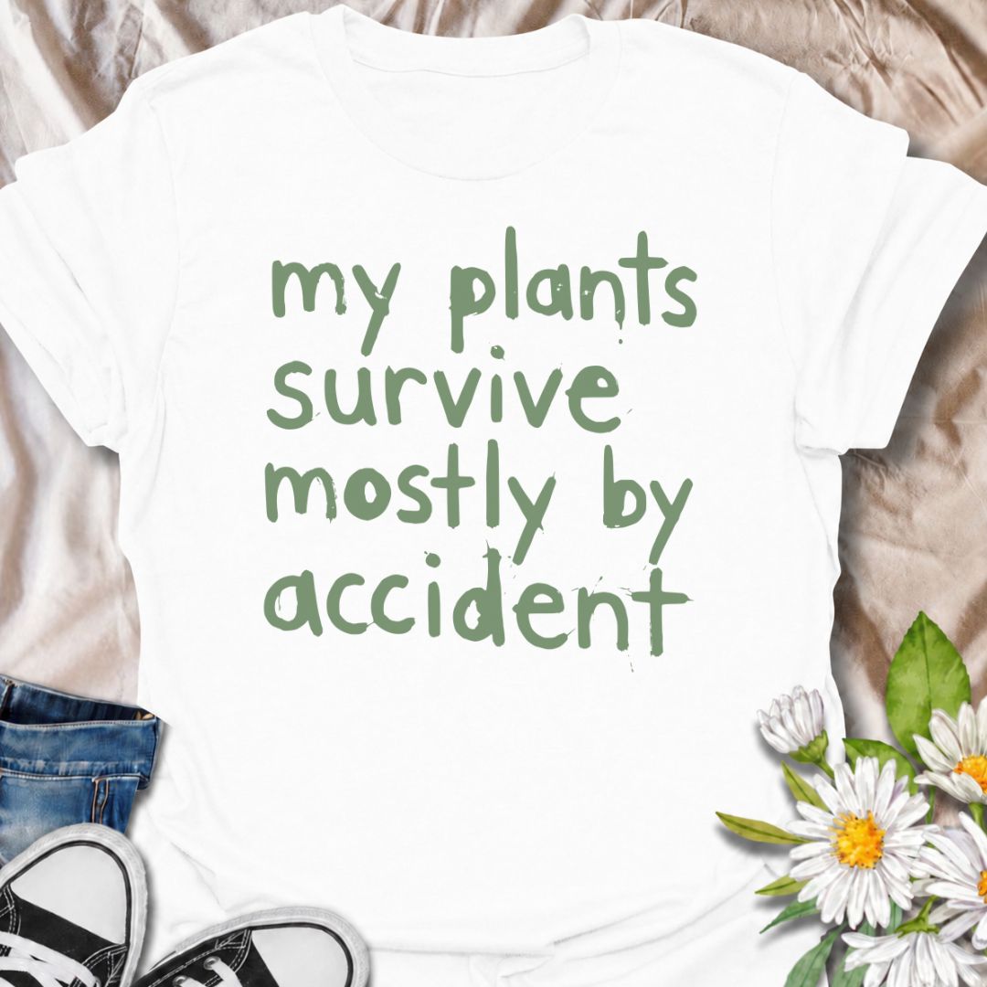 A funny plant T-shirt for anyone whose houseplants are doing surprisingly well despite a slightly questionable care routine. The phrase “My Plants Survive Mostly by Accident” delivers dry, self-deprecating humor that plant parents and indoor gardeners will instantly relate to. Its simple hand-drawn typography keeps the design casual, modern, and easy to wear. It makes a great gift for houseplant lovers, accidental green thumbs, and anyone who is still figuring out what their plants actually need. Perfect fo