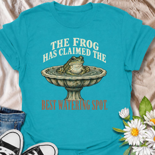 A funny gardening T-shirt for anyone whose garden wildlife has decided certain spots now belong to them. The phrase “The Frog Has Claimed the Best Watering Spot” pairs perfectly with a content-looking frog sitting in a birdbath for dry, relatable garden humor. It is ideal for backyard gardeners, wildlife gardeners, frog lovers, and anyone who enjoys seeing unexpected visitors around the garden. The vintage-style illustration gives the design personality while keeping it easy to wear. A great gift for garden