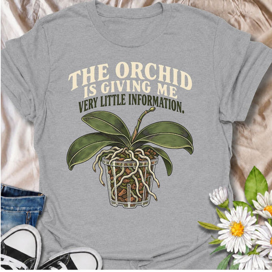 A funny orchid T-shirt for anyone who has stared at their plant trying to work out what it actually wants. The phrase “The Orchid Is Giving Me Very Little Information” captures the mysterious side of orchid care with dry, relatable plant-parent humor. Featuring a detailed orchid in a clear pot with exposed roots and bark, this design is perfect for orchid lovers, houseplant collectors, and indoor gardeners. It makes a great gift for anyone who has questioned whether their orchid is thriving, sulking, thirst