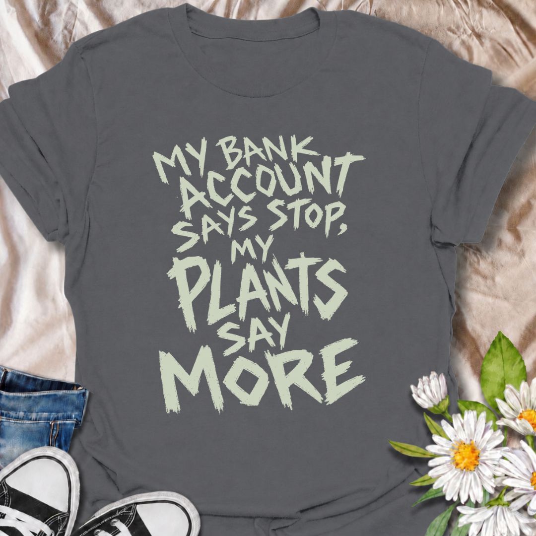 A funny plant T-shirt for anyone whose budget says stop but whose houseplant collection has other ideas. The phrase “My Bank Account Says Stop, My Plants Say More” delivers relatable plant-shopping humor for collectors who can never quite resist another plant. Its bold hand-drawn typography gives the design an expressive, slightly chaotic feel that suits the joke perfectly. It makes a great gift for plant parents, nursery regulars, and anyone whose indoor jungle keeps growing faster than their savings. Perf